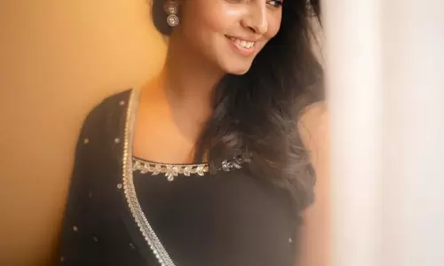 Preethi Asrani Stands by the Window in Black Suit