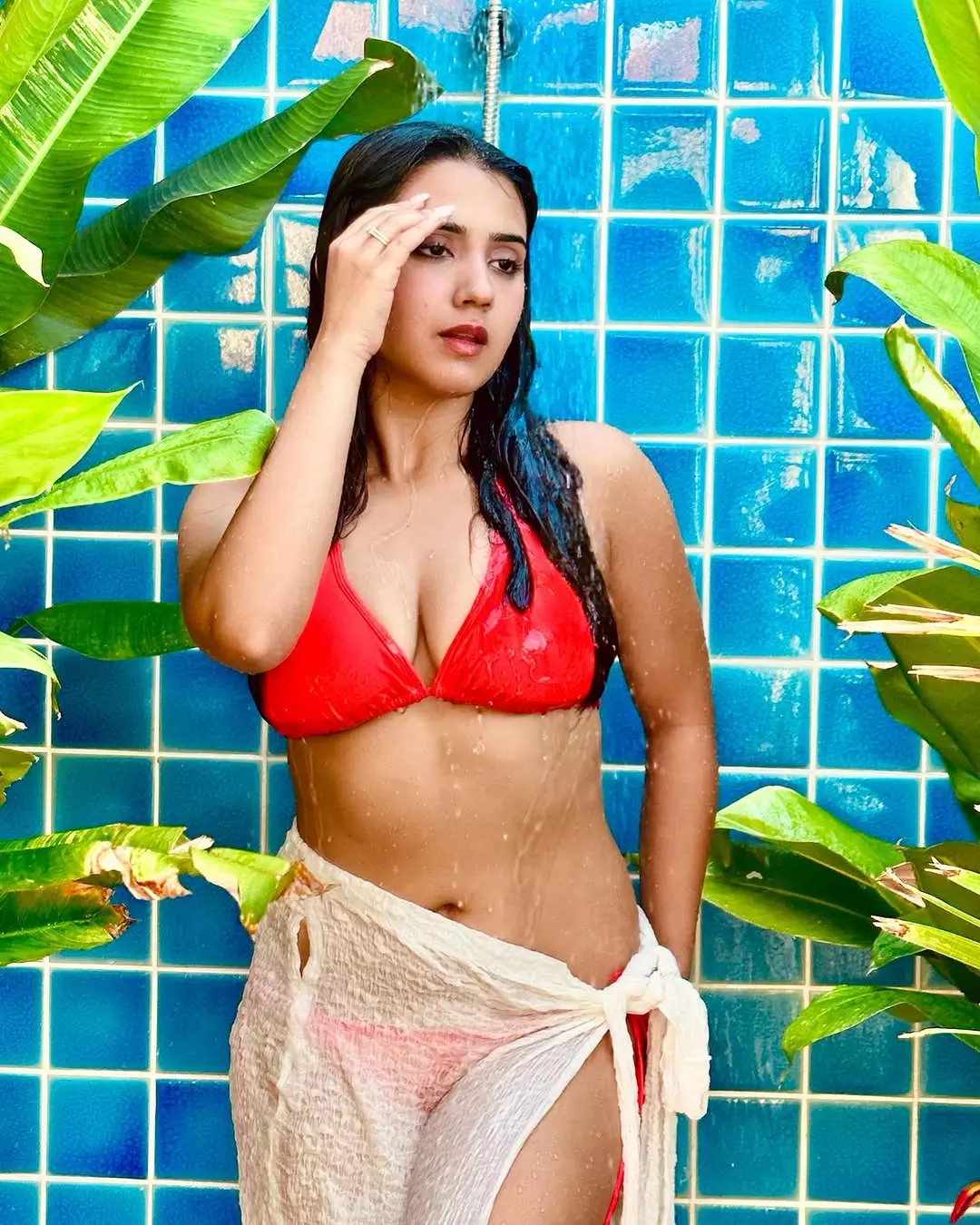 Roshni Walia Stuns In Fiery Red Bikini Amid Lush Outdoor Shower Setting