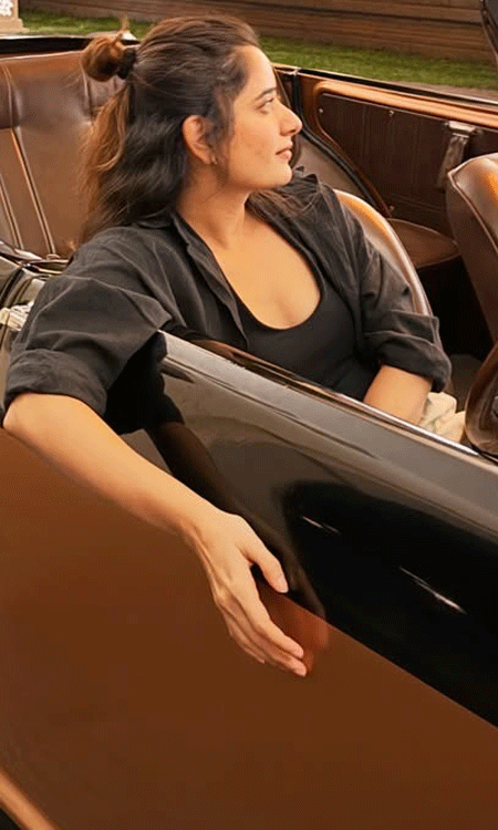 Ashika Ranganath Looks Stylish in a Black Outfit by a Vintage Convertible