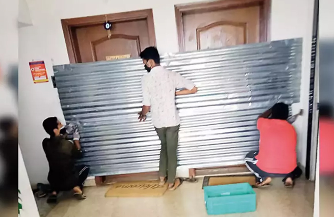 కరోనా వచ్చిందని అపార్ట్ మెంట్ కు రేకులతో సీల్